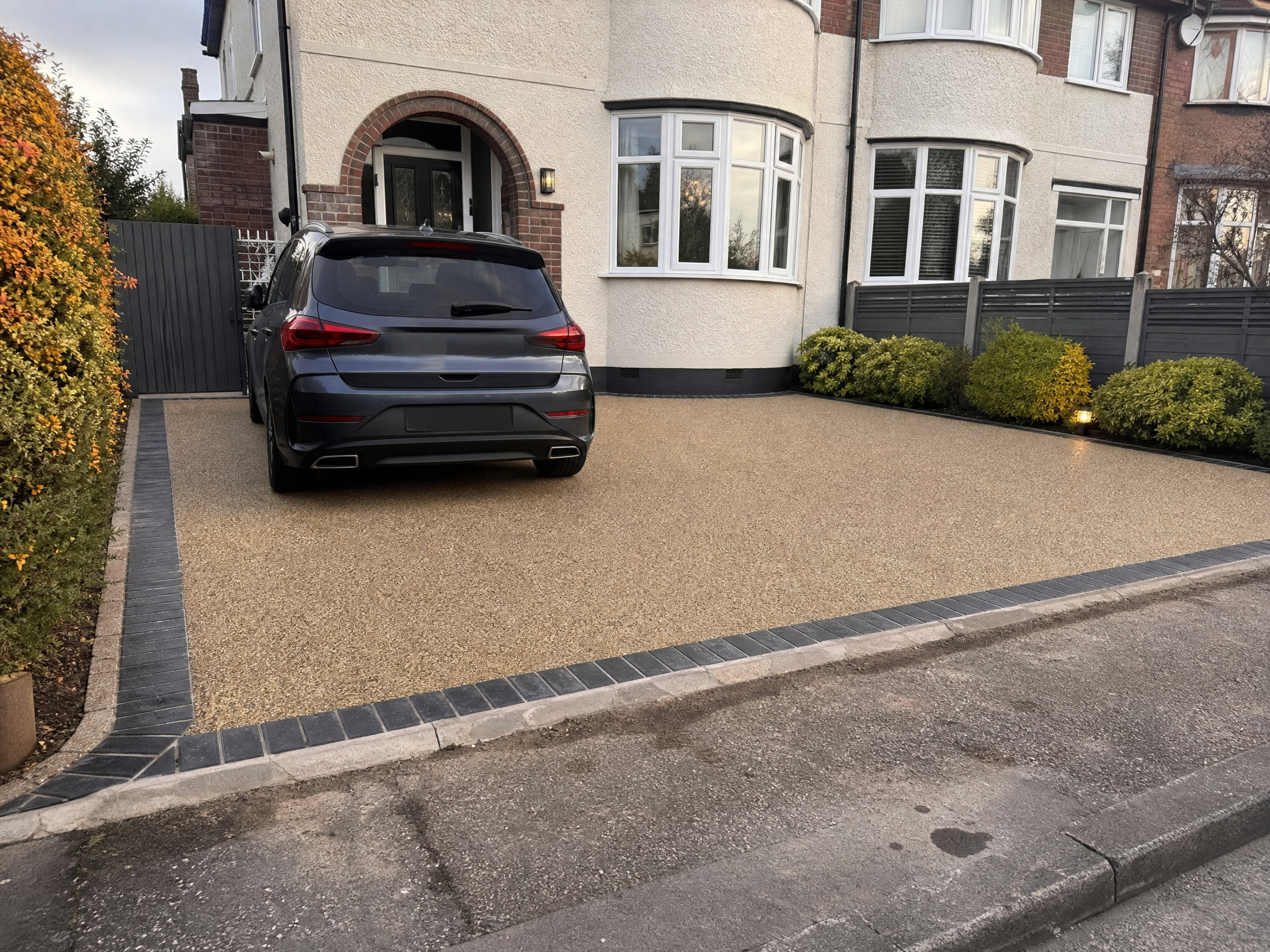 Finished resin driveway with block-paved border and a car parked on it in Kettering