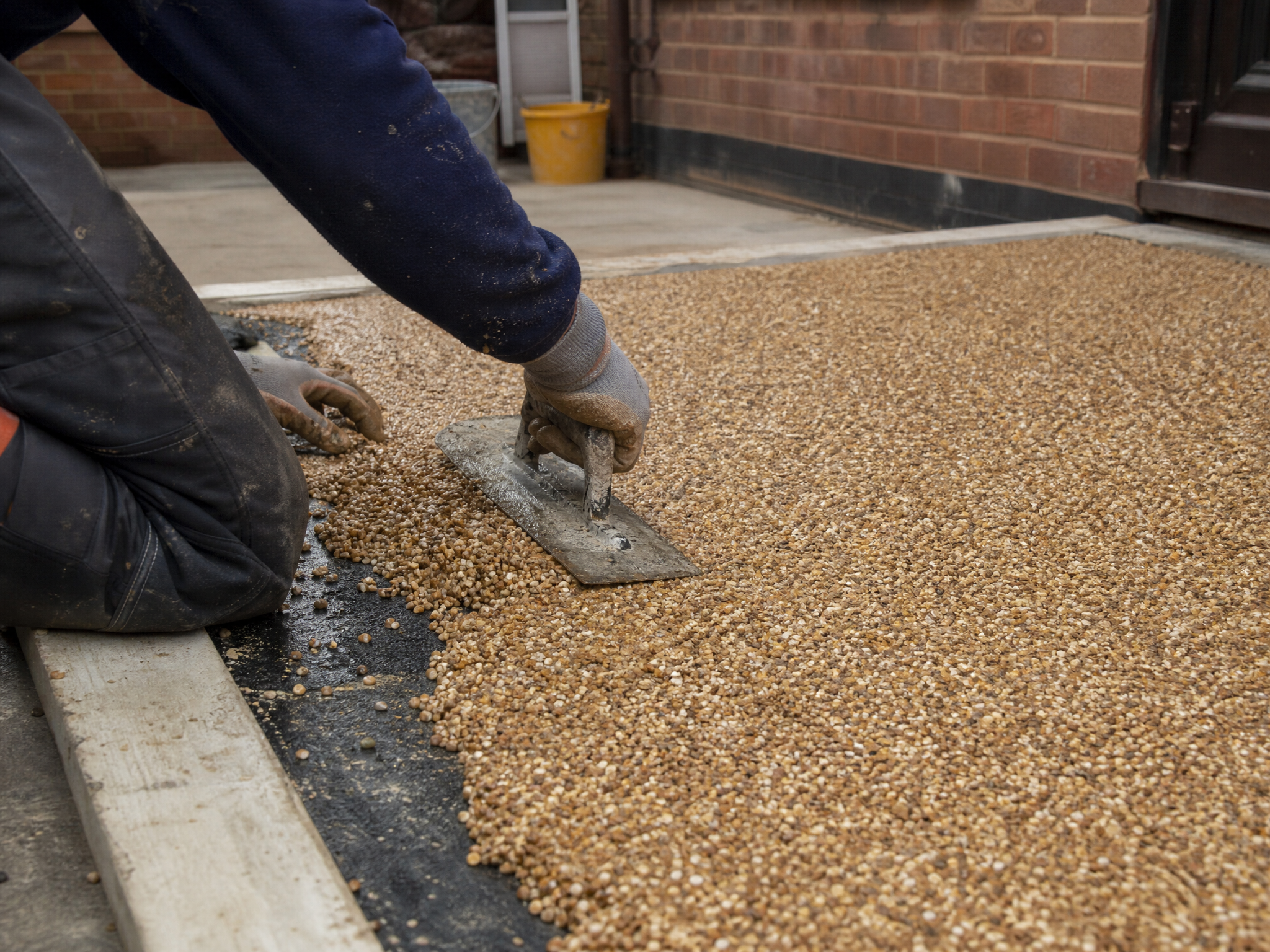 Professional installer carrying out resin patios in a British residential property
